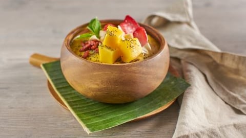 a bowl of fruit sitting on top of a wooden table